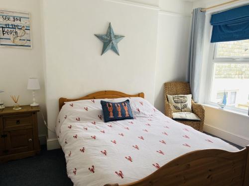 a bedroom with a bed with a starfish bedspread at Ocean Terrace, Ilfracombe Spacious, Sleeps 8, Stunning Sea Views, Parking, Garden, Pet Friendly in Ilfracombe