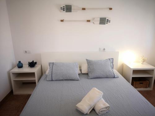 - une chambre blanche avec un lit et deux oreillers dans l'établissement Villa Montse, à Les tres Cales