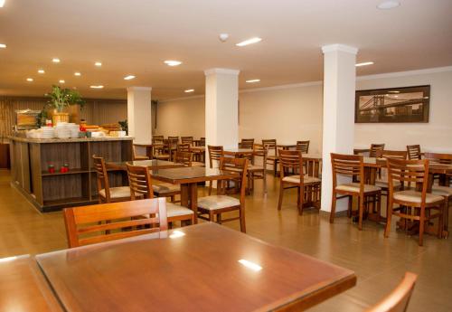 a dining room filled with tables and chairs at Hotel Zé Maria in Pouso Alegre