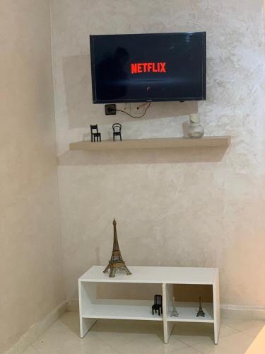 a white table with a tv on a wall at cozy appartement meublé in Tangier