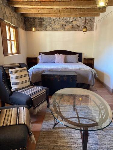 a bedroom with a bed and a table and a couch at Hotel Amor y Paz in Real de Catorce