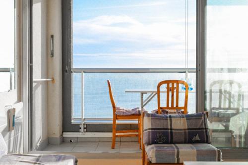 un balcon avec une table et des chaises et une vue sur l'océan dans l'établissement Grand studio face mer Les Sables d'Olonne 4 personnes, à Les Sables-dʼOlonne
