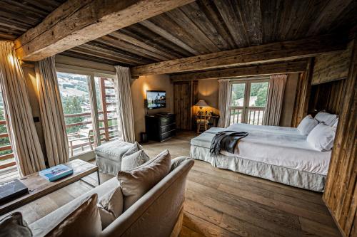 um quarto com uma cama e um sofá num quarto em Zannier Hotels Le Chalet em Megève
