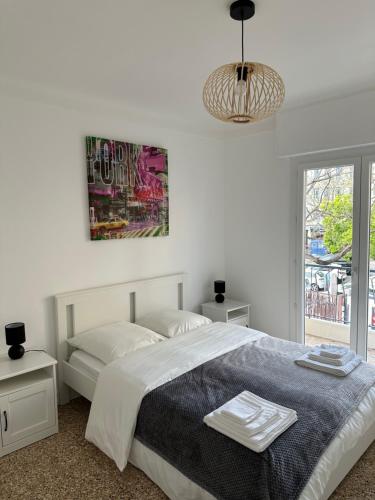 une chambre blanche avec un lit et une grande fenêtre dans l'établissement Appartement Cannes, à Cannes