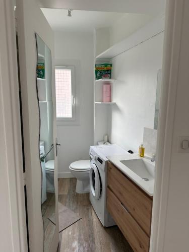 une salle de bain avec un lavabo et une machine à laver dans l'établissement Appartement Cannes, à Cannes