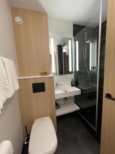 a bathroom with a toilet and a sink and a shower at ibis Laon in Laon