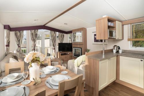 a kitchen and living room with a table and chairs at BUNNY - 3 Bed Static Caravan in Port Seton