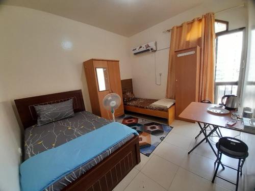 1 dormitorio con cama, escritorio y mesa en Adbldna01, en Abu Dabi