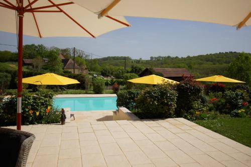 un patio con ombrelloni e una piscina di Chambres d'Hôtes La Bonne Voie a Lembras