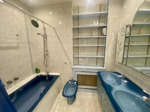 La salle de bains est pourvue d'une baignoire bleue, de toilettes et d'un lavabo. dans l'établissement Grand F3- Centre ville de Nice, Wifi AC, à Nice