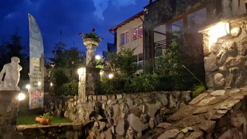 a stone wall in front of a building at night at Villa Titanic Residence Spa in Azuga