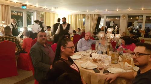 Villa Titanic Residence Spa في أَزوغا: مجموعة من الناس يجلسون على طاولة في مطعم