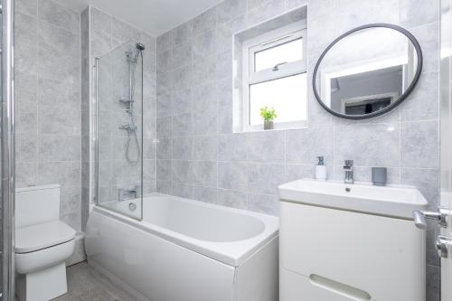 a bathroom with a sink toilet and a mirror at Leeds 3 Bed 2 Bath - Off Road Parking, Self Check-in, Fast Wi-Fi, Table Football - Families, Contractors, Long Stays in Bramley