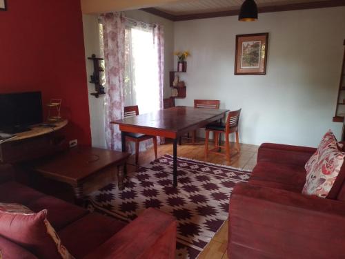 a living room with a table and a couch at Casa el Jardin in Fortuna