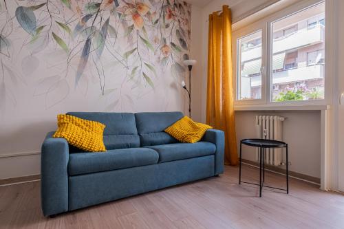 un sofá azul con almohadas amarillas en la sala de estar. en San Pietro Dream House, en Roma