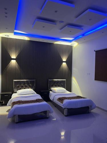 two beds in a room with blue lights at Dar Al Karama Residential Units in AlUla