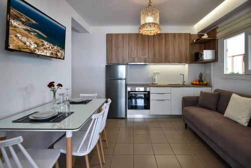 a kitchen and living room with a table and a couch at Villa Thalassa in Milatos