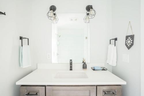 a white bathroom with a sink and a mirror at Cute & Cozy - Perfect for Business or Leisure in Covington