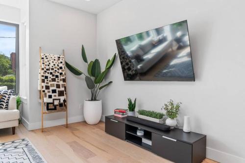a living room with a tv on a white wall at The Mr. Rogers Room - Private Room on Arch Street in Pittsburgh