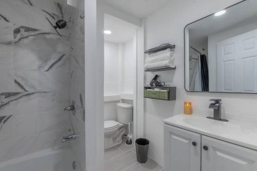 a bathroom with a shower and a sink and a mirror at Posh Suite with 2 Queen Beds, Full Kitchen, Sleeps 6, by Train, 15 min to NYC in Hoboken