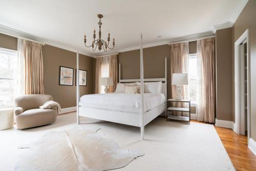 a bedroom with a white bed and a chandelier at Church St Collection - 109 Whole House and Pool in Fairhope