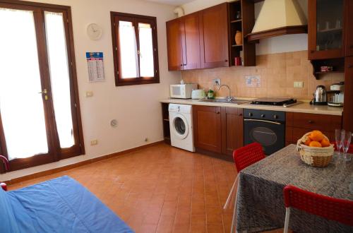 een keuken met een tafel en een wasmachine bij Guest House Guicciardini in Reggio Emilia