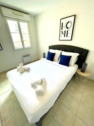 - un grand lit blanc avec 2 serviettes dans l'établissement Royal Plazza, beau T2 centre ville, parking, à Menton