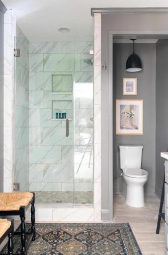 a glass shower in a bathroom with a toilet at Church St Collection - 109 Whole House and Pool in Fairhope