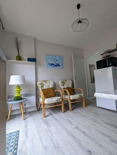 une chambre avec deux chaises et une table avec une lampe dans l'établissement Appartement à 300m des thermes, à Cazaubon