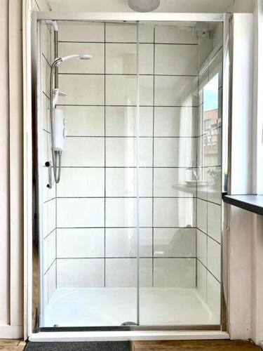 La salle de bains est pourvue d'une douche avec une porte en verre. dans l'établissement Cosy Apartment Studio Close to Cafes, à Norwich