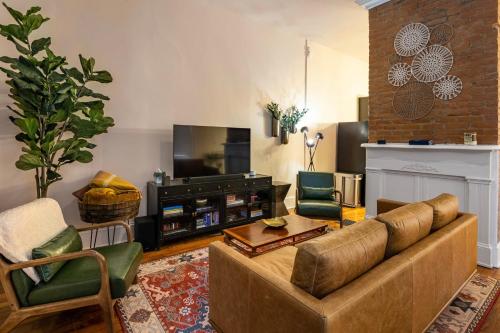 a living room with a couch and a tv at Goldie on Greer - Perfect for 4 in Covington
