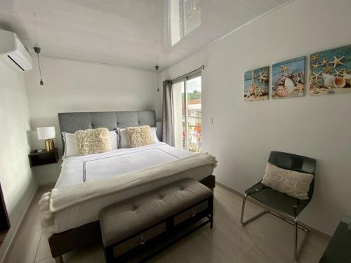 1 dormitorio con 1 cama grande y 1 silla en Hotel Boutique Doña Maria en Ocaña