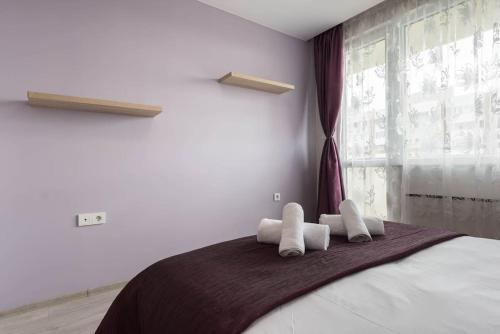 een slaapkamer met een groot bed en witte handdoeken bij Linden Guest Apartment in Varna