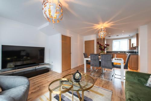 een woonkamer met een bank en een tafel bij THE RISE - A beautiful 2 bedroom house, only 17mins to Central London!!! in Northfleet