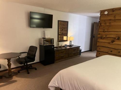 Dormitorio con cama, escritorio y TV en Bridge Inn Tomhawk - 2nd Floor, 1 King Size Bed, Balcony, River View, en Tomahawk