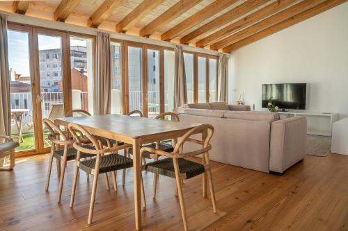 sala de estar con mesa, sillas y sofá en La Gallega by Upper Luxury Housing, en A Coruña