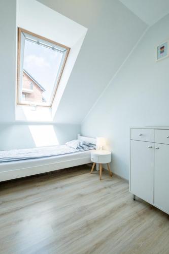a bedroom with a bed and a window at Bedroom - domek nr 1 in Łeba