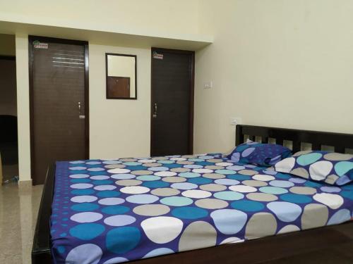 1 dormitorio con 1 cama con edredón azul y blanco en Anithaas Cottage, en Kuttālam