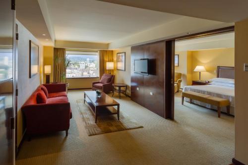 een hotelkamer met een bed en een woonkamer bij Sheraton Mendoza Hotel in Mendoza