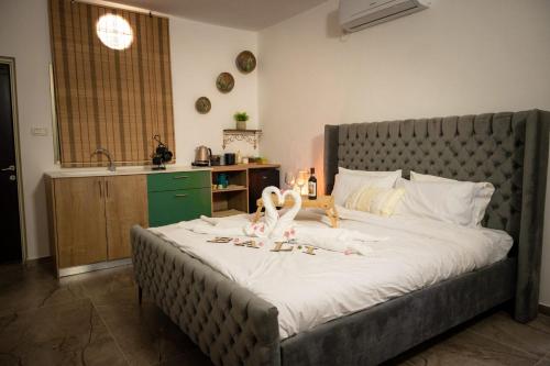 Un dormitorio con una cama grande con dos animales de peluche. en bali carmel zimmer & spa en Dāliyat el Karmil