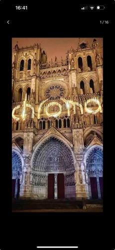 Un bâtiment avec des lumières à l'avant dans l'établissement APPT 4 Proche gare d'Amiens et du centre ville, à Amiens