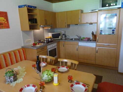 eine Küche mit einem Holztisch sowie einem Tisch und Stühlen in der Unterkunft Scheurerhof in Tux