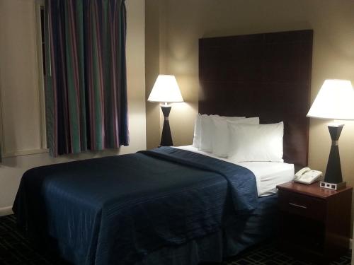 Habitación de hotel con 1 cama con 2 lámparas y teléfono en Barclay Hotel Atlanta Downtown, en Atlanta