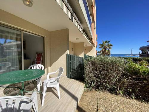 un patio avec une table et des chaises et l'océan dans l'établissement Studio climatisé avec jardin en front de mer, proche commerces, garage fermé - FR-1-100-334, à Cavalaire-sur-Mer
