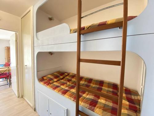 Ce lit superposé se trouve dans un dortoir avec une échelle. dans l'établissement Studio climatisé avec jardin en front de mer, proche commerces, garage fermé - FR-1-100-334, à Cavalaire-sur-Mer