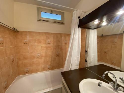 une salle de bain avec un lavabo et une baignoire dans l'établissement Studio climatisé avec jardin en front de mer, proche commerces, garage fermé - FR-1-100-334, à Cavalaire-sur-Mer