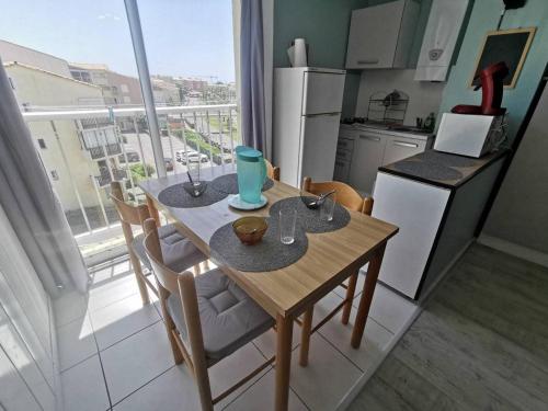 une petite cuisine avec une table et des chaises ainsi qu'une fenêtre dans l'établissement 035 Hameau C31, au Cap d'Agde