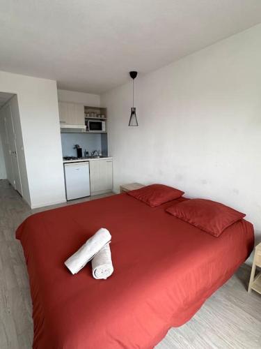 - une chambre avec un grand lit rouge et des draps rouges dans l'établissement Le Cocon - proche gare et centre ville, à Lourdes
