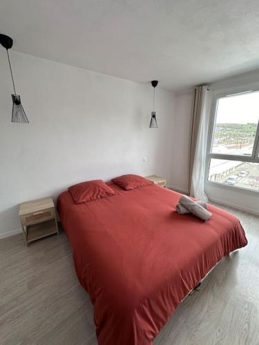 - une chambre avec un lit rouge et une fenêtre dans l'établissement Le Cocon - proche gare et centre ville, à Lourdes