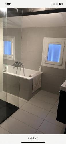 une salle de bain avec une baignoire et une fenêtre dans l'établissement Villa contemporaine face à la Sainte Victoire, à Belcodène